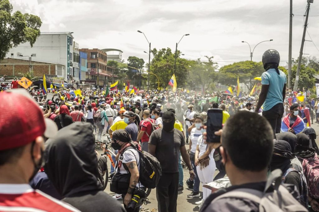 Manifestación en las calles de Cali durante el Paro Nacional. Hay muchas personas, dee espaldas alguien está registrando con su celular lo que sucede.