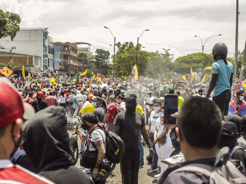 Manifestación en las calles de Cali durante el Paro Nacional. Hay muchas personas, dee espaldas alguien está registrando con su celular lo que sucede.