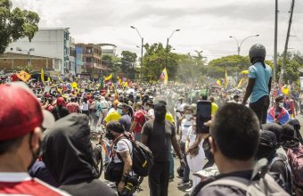 Manifestación en las calles de Cali durante el Paro Nacional. Hay muchas personas, dee espaldas alguien está registrando con su celular lo que sucede.